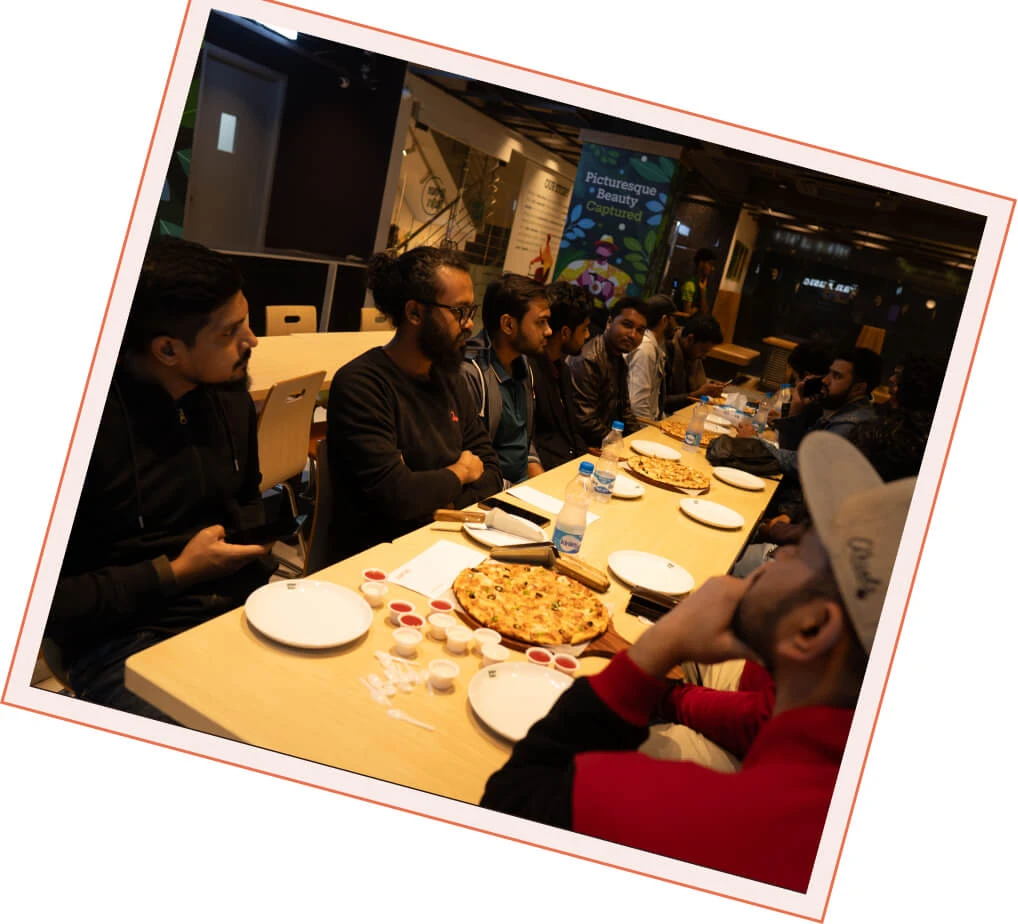 Panze team members talking over pizza at a team dinner