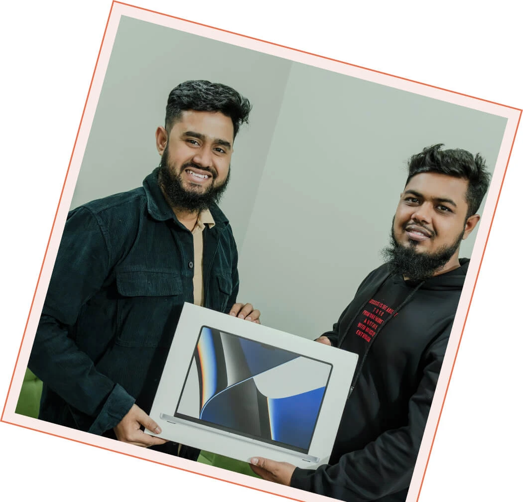 Two Panze team members smiling as they hold up a new MacBook